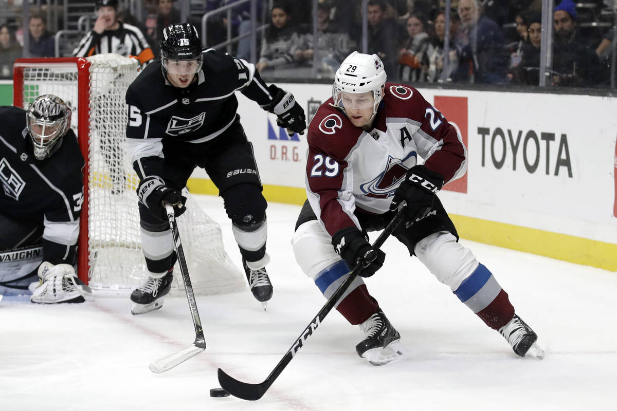 Colorado Avalanche's Nathan MacKinnon (29) is chased by Los Angeles Kings' Ben Hutton (15) duri ...