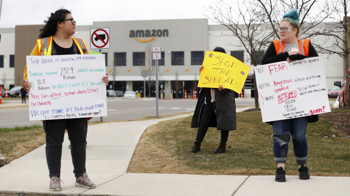 Employee's Breana Avelar, left, and Tonya Ramsay, right, hold signs outside the Amazon DTW1 ful ...