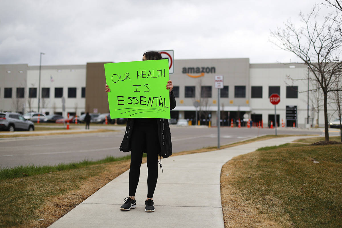 A family member of an employee holds a sign outside the Amazon DTW1 fulfillment center in Romul ...