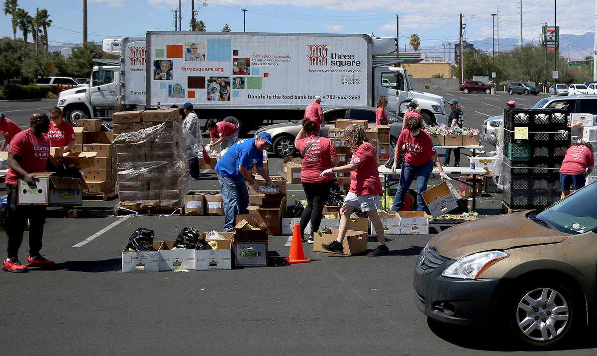 Volunteer with Three Square Food Bank give out food at Palace Station Casino in Las Vegas, Thur ...