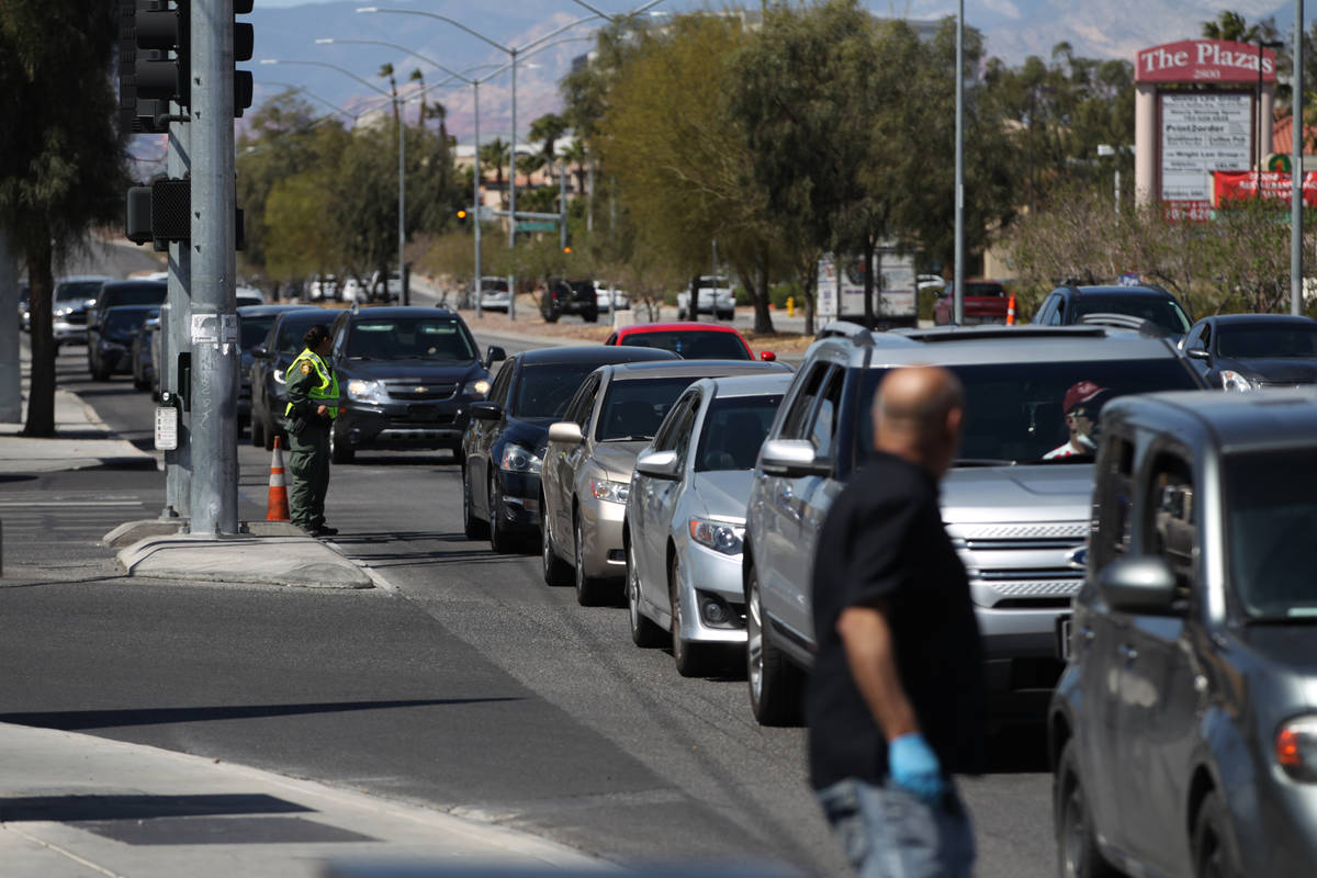 Hundreds of people in their vehicles wait to receive food from Three Square Food Bank at Palace ...