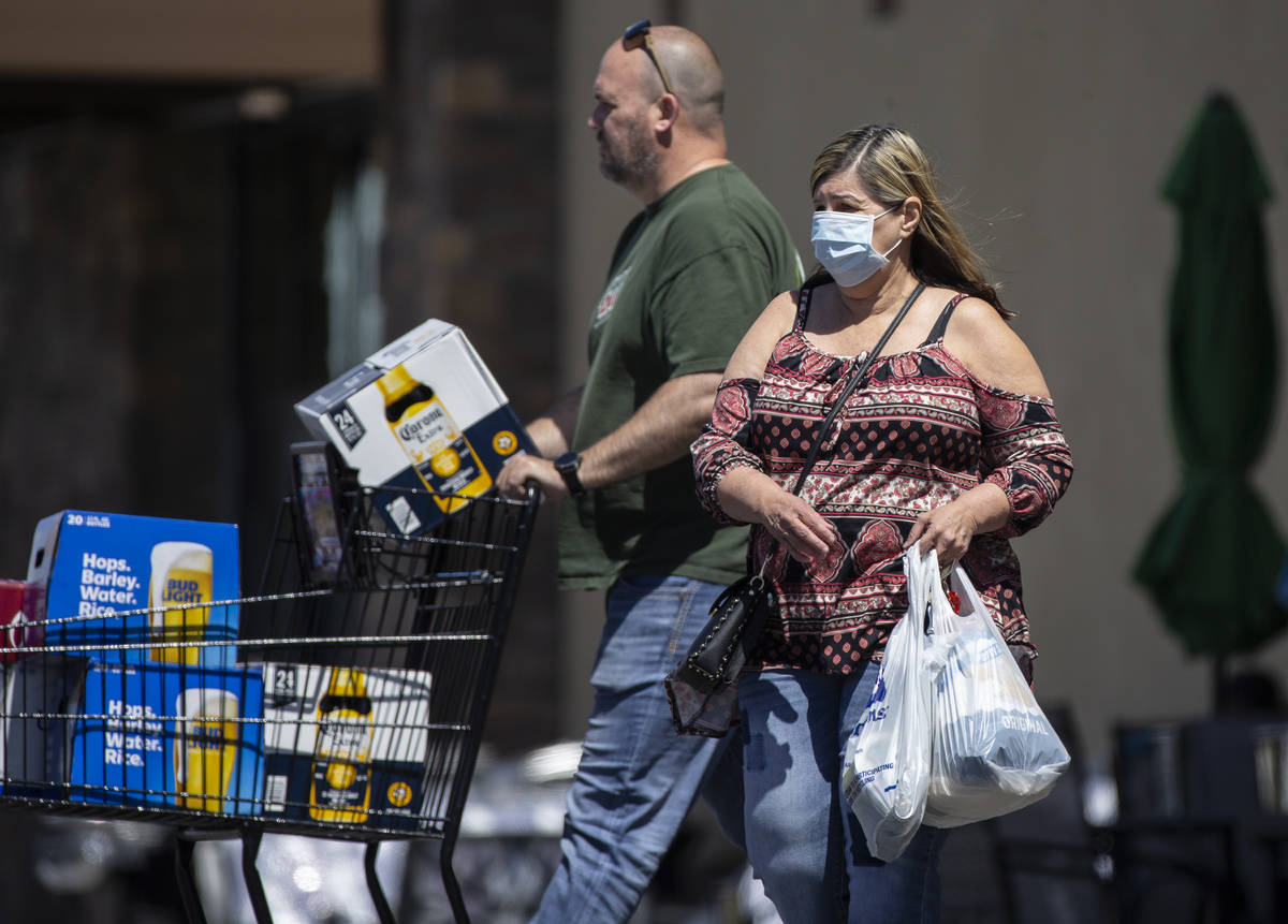 Shoppers wear protective masks outside Albertsons at North Hualapai Way in the northwest valley ...