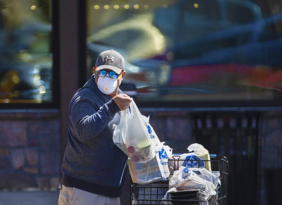 Shoppers wear protective masks outside Albertsons at North Hualapai Way in the northwest valley ...
