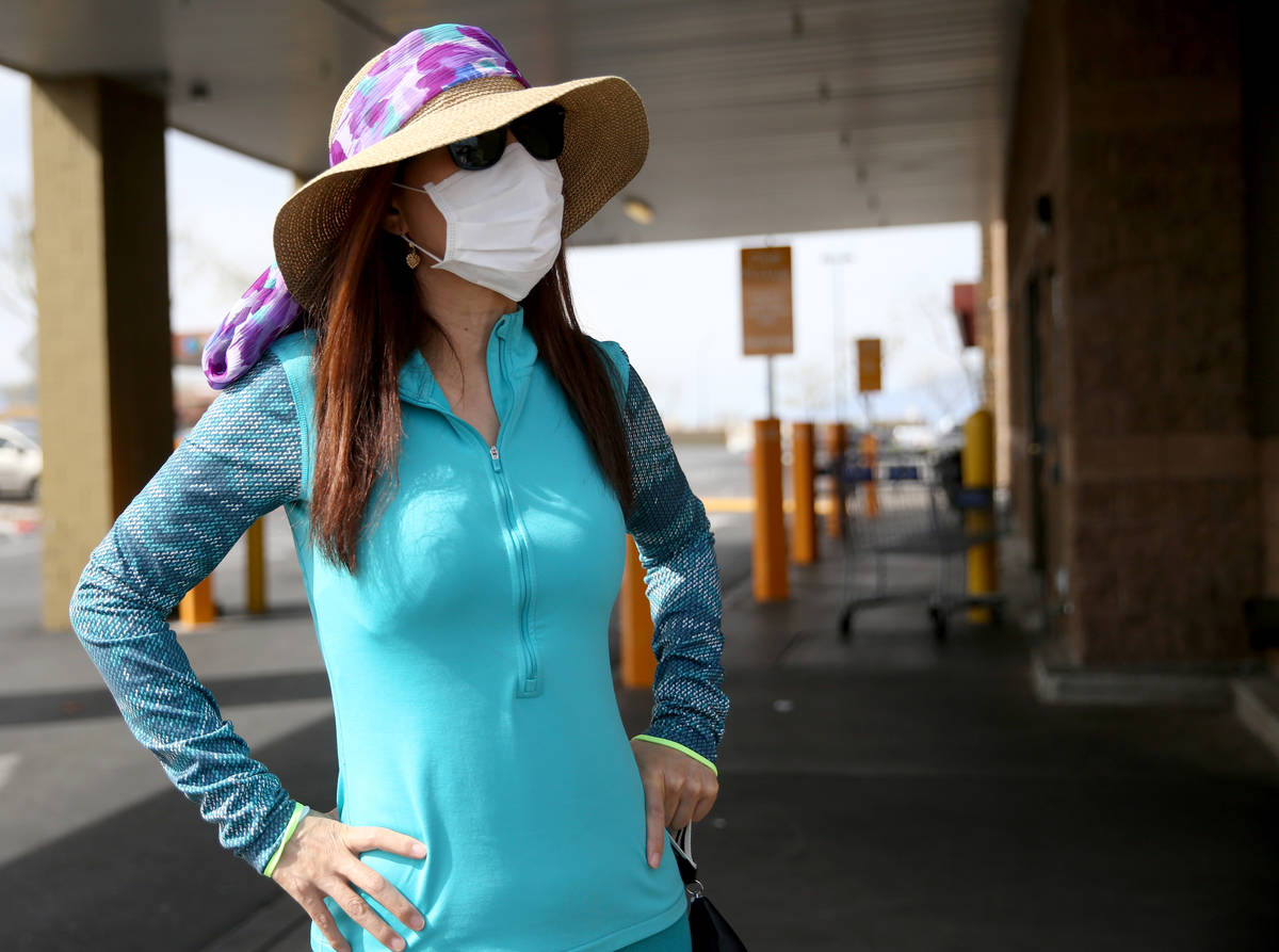 Heather Neil, 55, of Las Vegas, dons a mask while shopping at Sam's Club in southwest Las Vegas ...