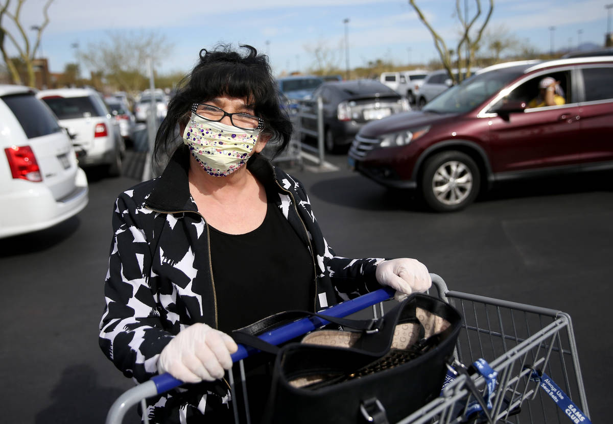 Zlata Petrouic, 60, of Las Vegas, dons a mask while shopping at Sam's Club in southwest Las Veg ...