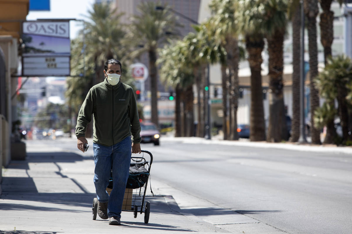Jason Morciglio walks down Las Vegas Boulevard wearing a mask to protect himself from COVID-19 ...