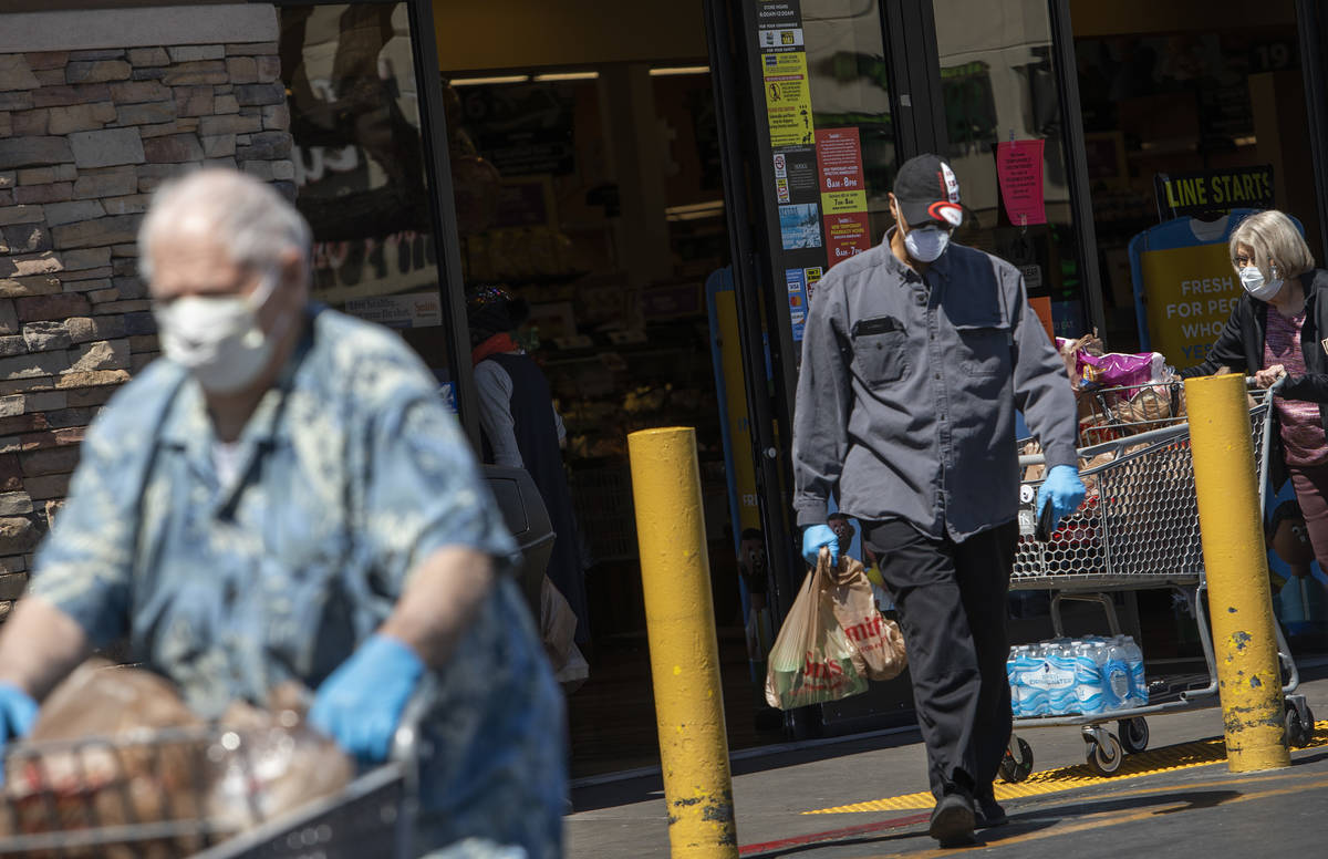 Masked shoppers exit Smith's Food and Drug on South Rancho Drive on Friday, April 3, 2020, in L ...