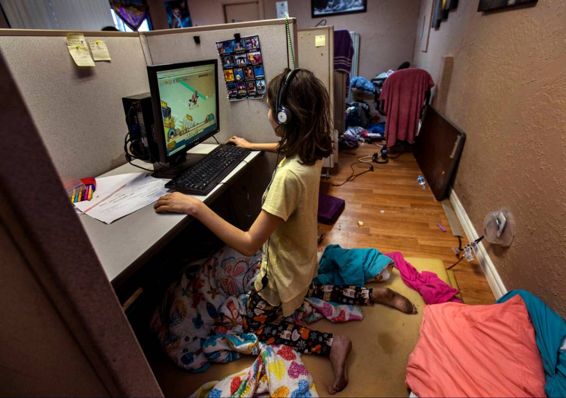 Aubrie Heenan, 17, left, plays Animal Crossing within her makeshift bedroom in a small office s ...