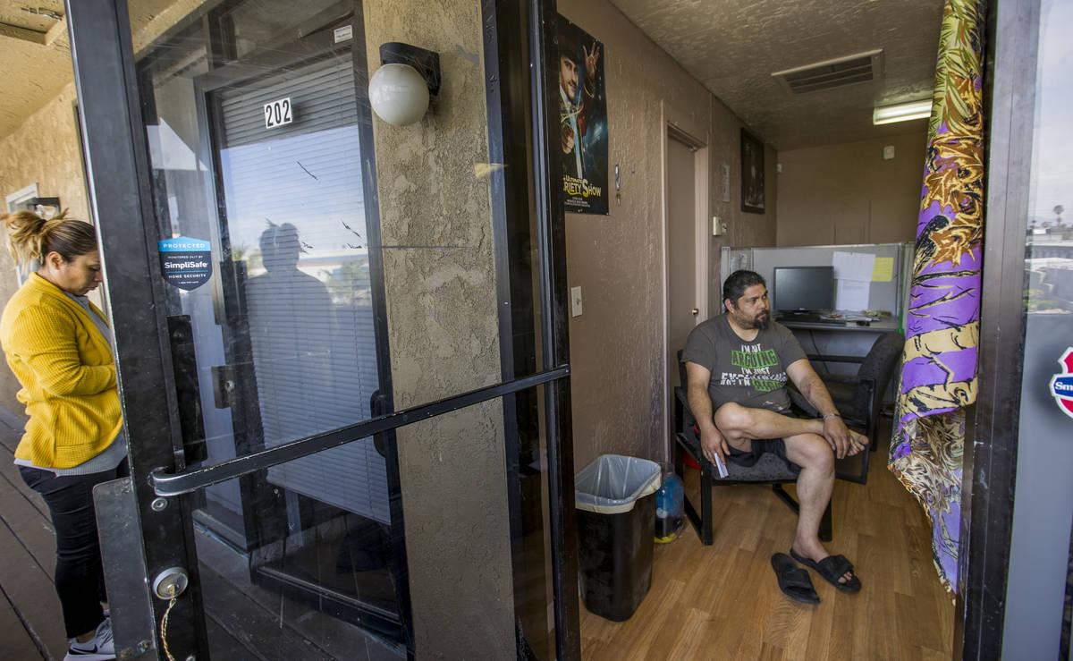 Jeremy Ferreira, right, sits a small office space he and his family of five are temporarily liv ...