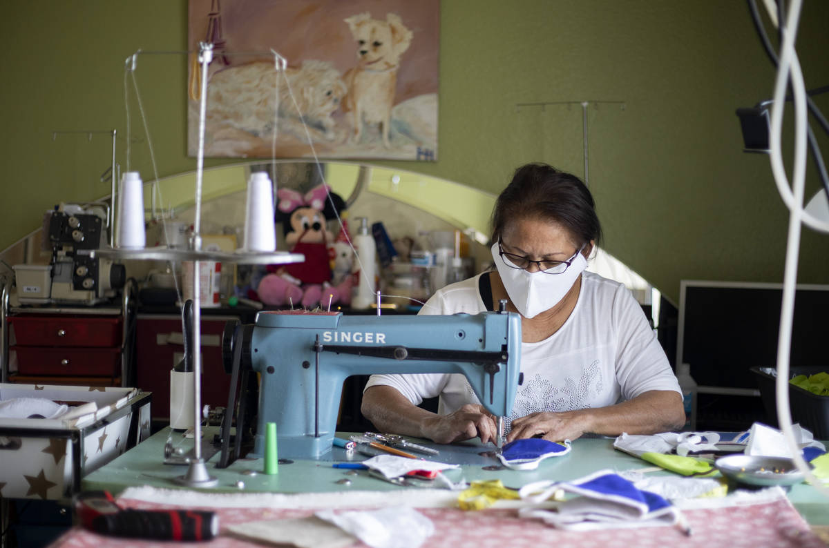 Alia Berry sews masks, meant to protect people from COVID-19, at her home on Friday, April 3, 2 ...