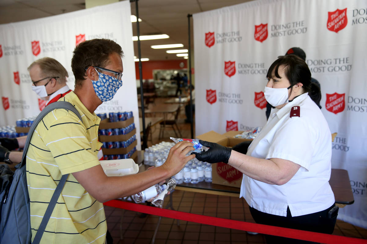 The Salvation Army Lieutenant Heather Baze gives a pandemic kit to Jose Gonzalez in North Las V ...