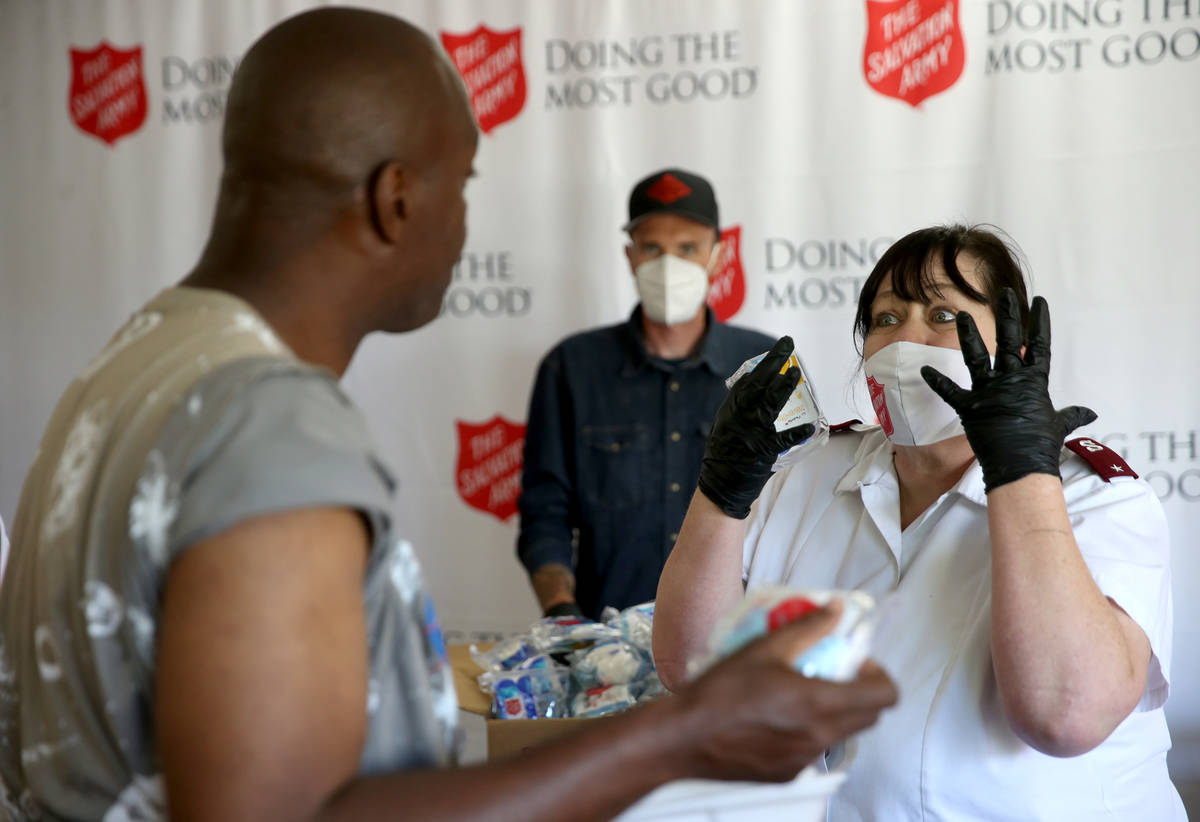The Salvation Army Lieutenant Heather Baze gives a pandemic kit to Demarlo Donahue, 46, in Nort ...