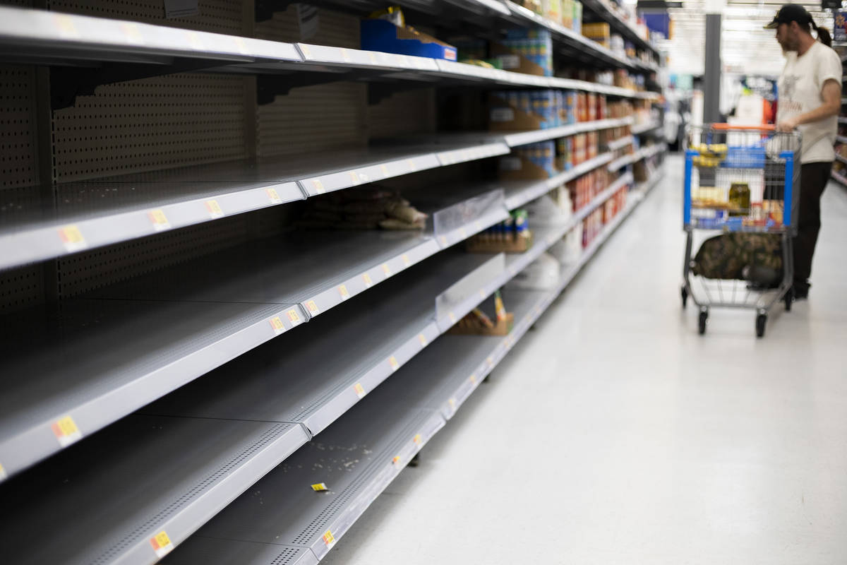 The rice and beans sections at Walmart are almost empty as Todd Holmgren shops for groceries on ...
