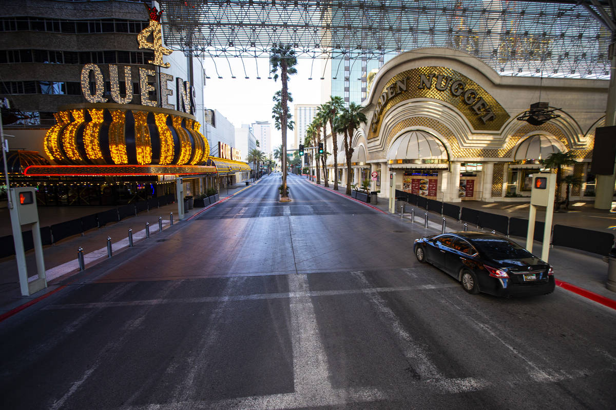A car drives down Casino Center Boulevard near Fremont Street as traffic remains light in the w ...