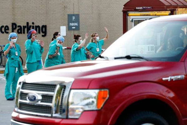 Piedmont Athens Regional Medical Center health care professionals stand and wave from the sidew ...