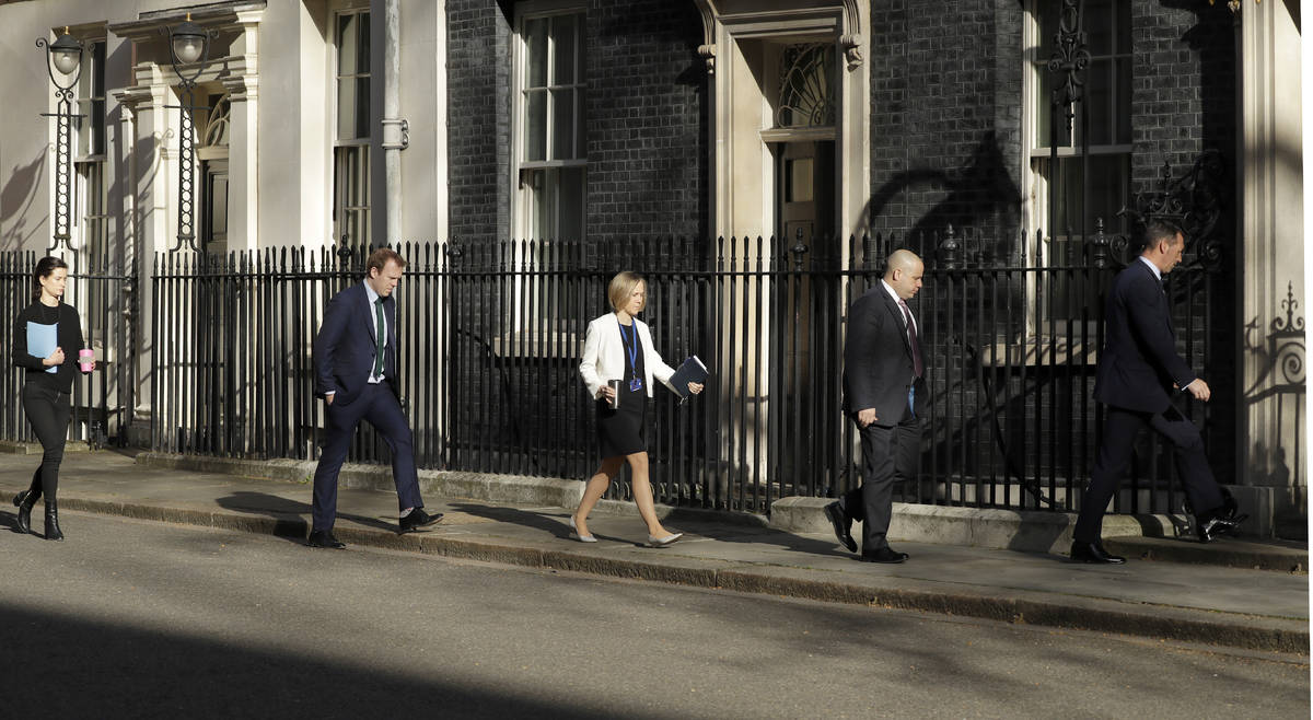 Members of a meeting keep their distance as they arrive at 10 Downing Street as British Prime M ...
