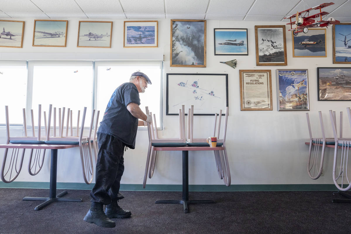 Sunshine & Tailwinds Cafe owner Stephen Maynard puts a sanitized chair up on the table at t ...