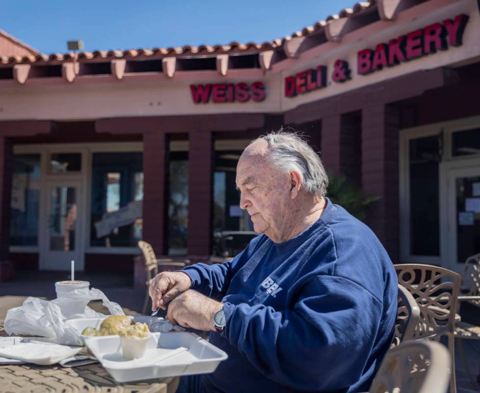 Forrest Darby, 76, long time customer of Weiss Deli and Bakery, eats his takeout order on the p ...