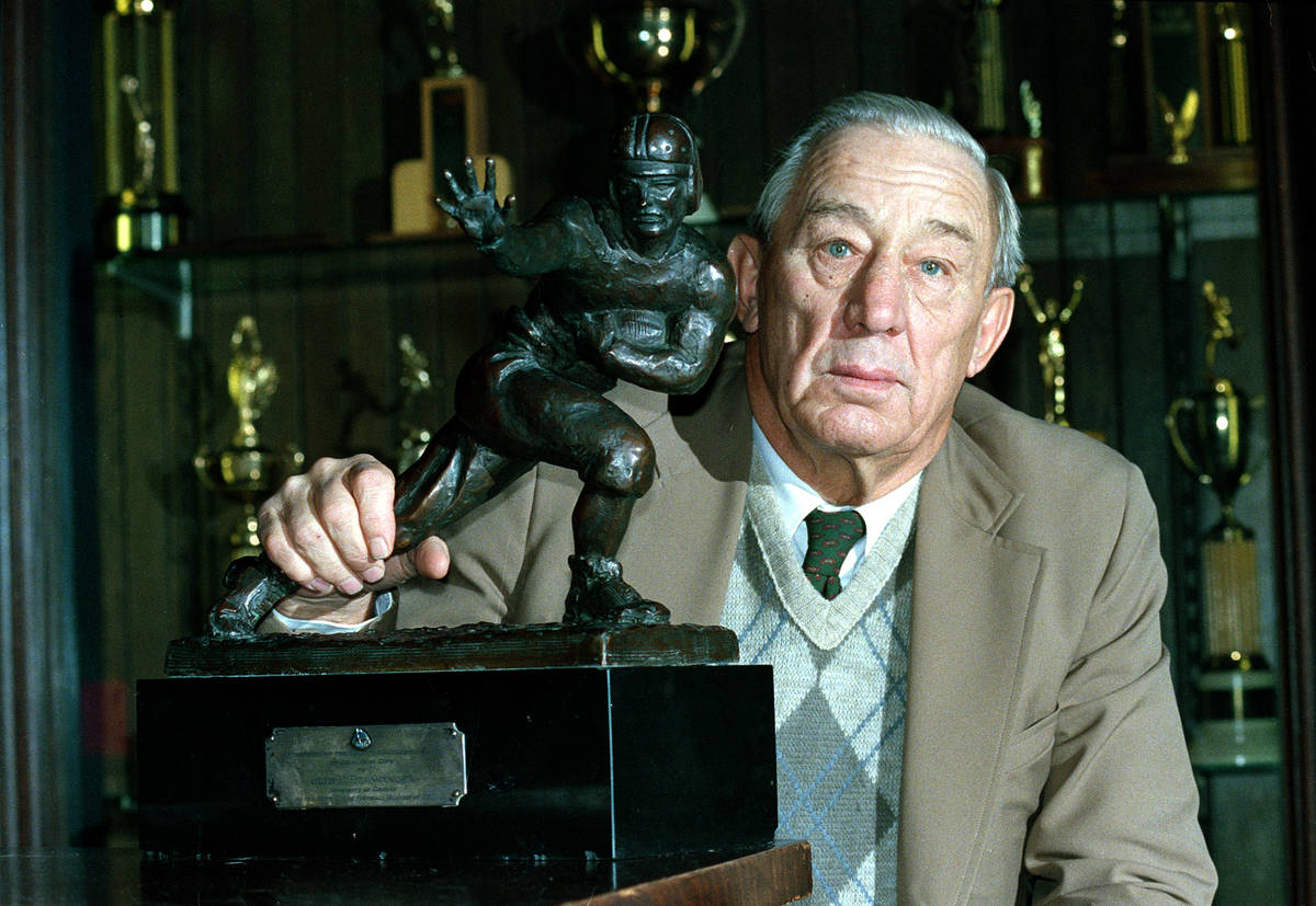 Jay Berwanger, 71, poses with the first Heisman Trophy, which he was awarded 50 years ago, at t ...