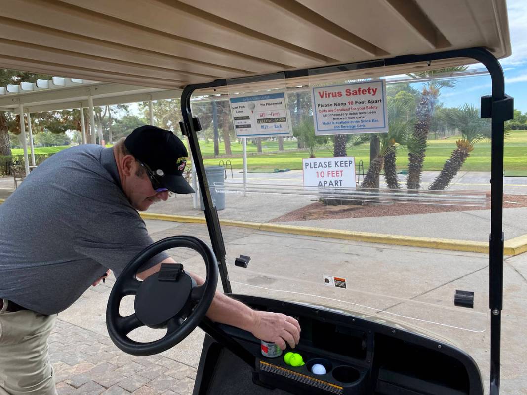 Timothy Metcalf of Las Vegas prepares for a round of golf among social distancing signs at Las ...