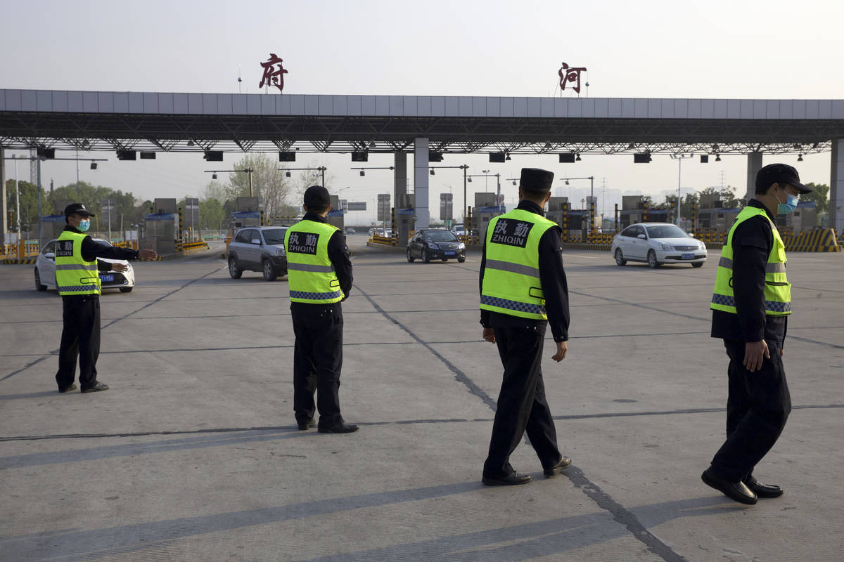 Security personnel wearing face masks to protect against the spread of new coronavirus direct v ...