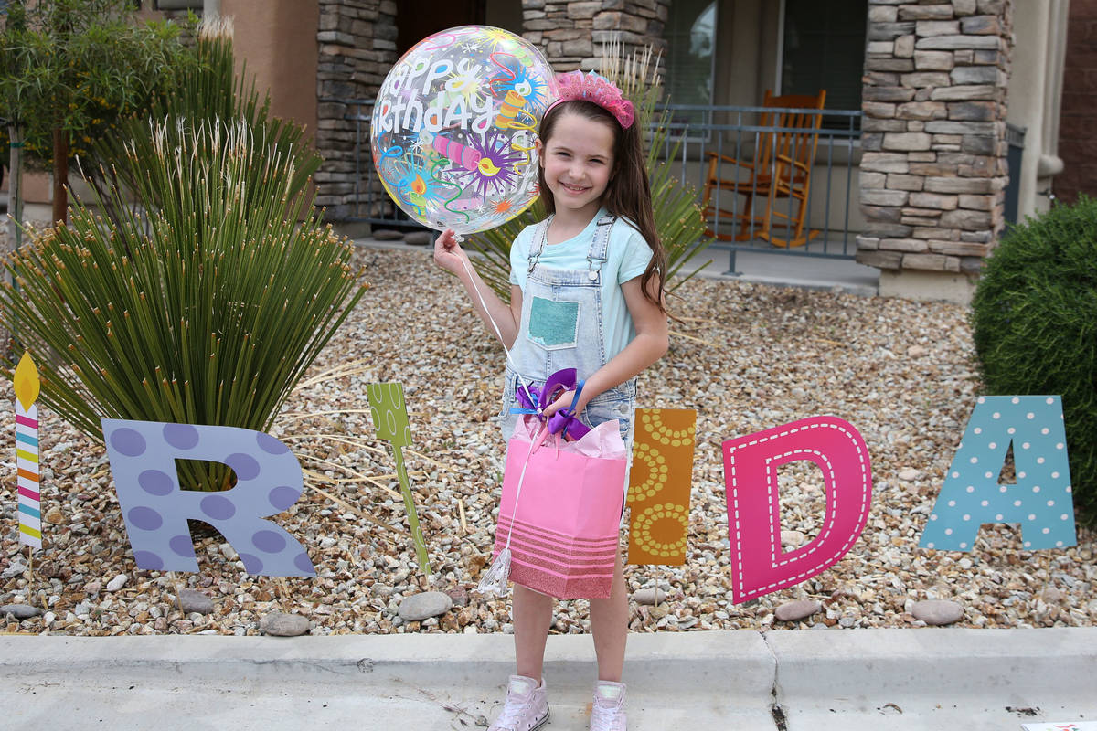 Tenley Hynds, 8, poses for a photo after receiving her birthday present after a drive by birthd ...