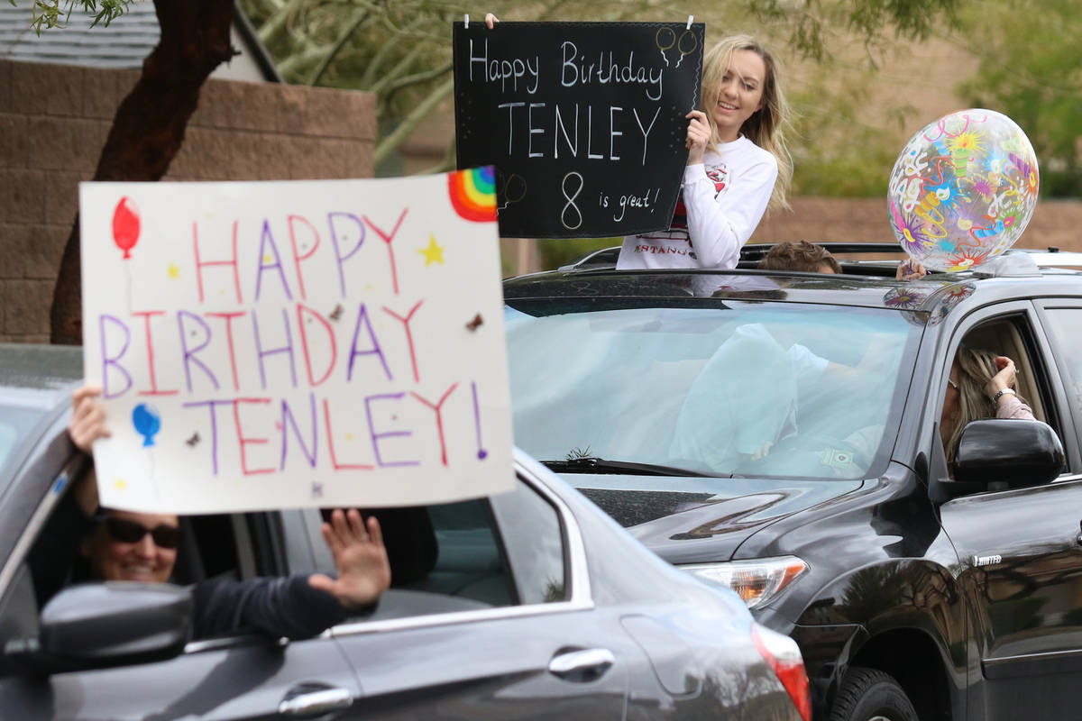 Amanda Grange, left, and Aba Rogers, 16, top right, hold birthday signs who came to celebrate T ...