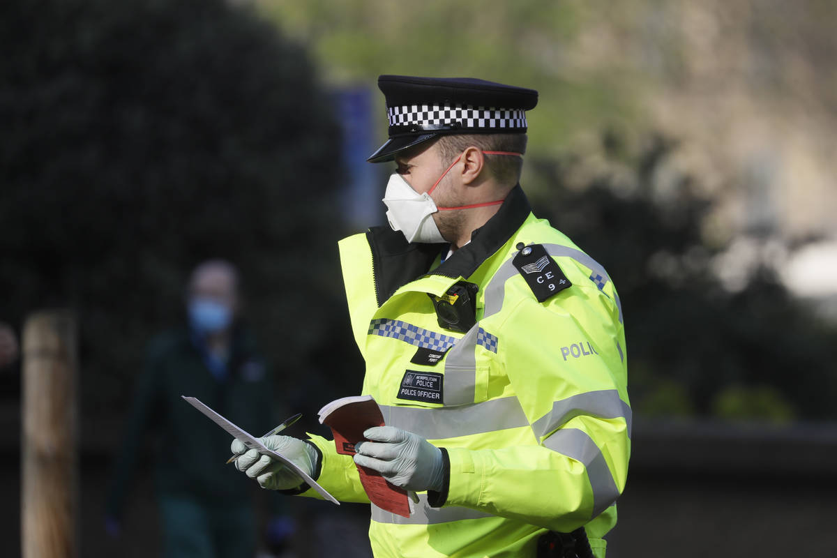 A British police officer wears a 3M face mask, with few police officers in Britain seen wearing ...