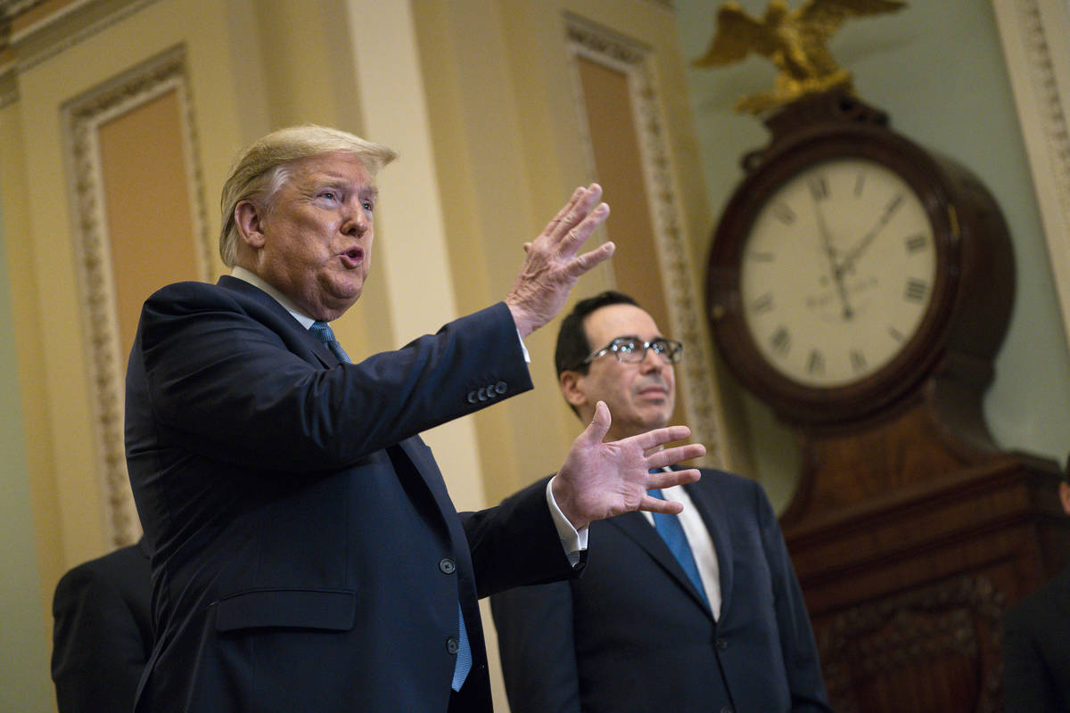 In a March 10, 2020, file photo, Treasury Secretary Steven Mnuchin listens as President Donald ...