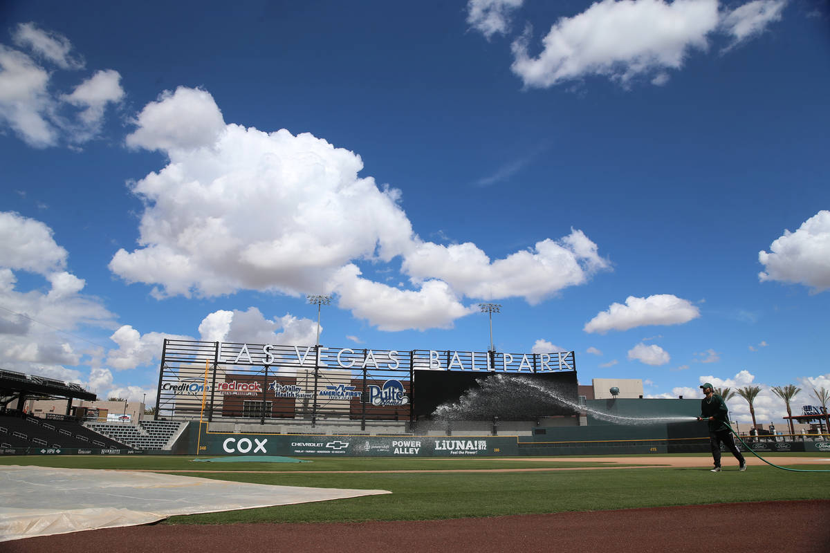 Groundskeeper Logan Mace sprays water on the field at the Las Vegas Ballpark in Las Vegas, Thur ...