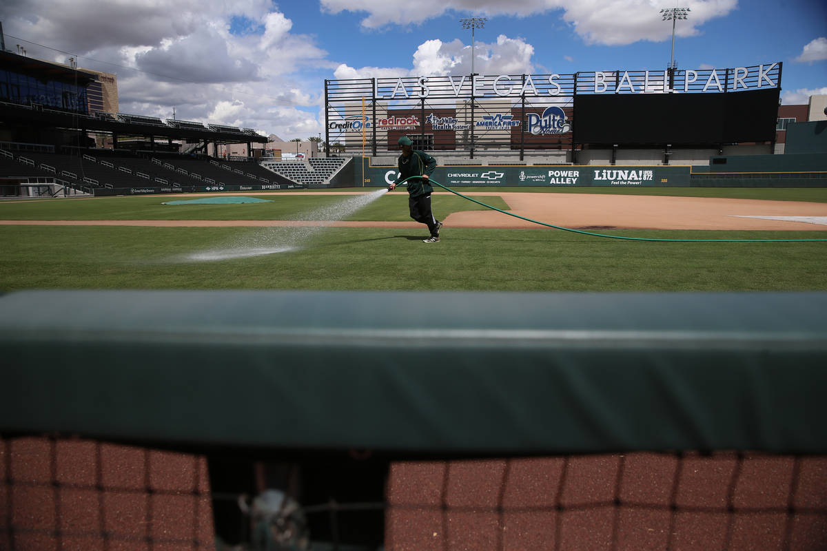 Groundskeeper Logan Mace sprays water on the field at the Las Vegas Ballpark in Las Vegas, Thur ...