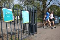 Signs on the gates reminding people to 'social-distance' at Victoria Park, in east London, afte ...