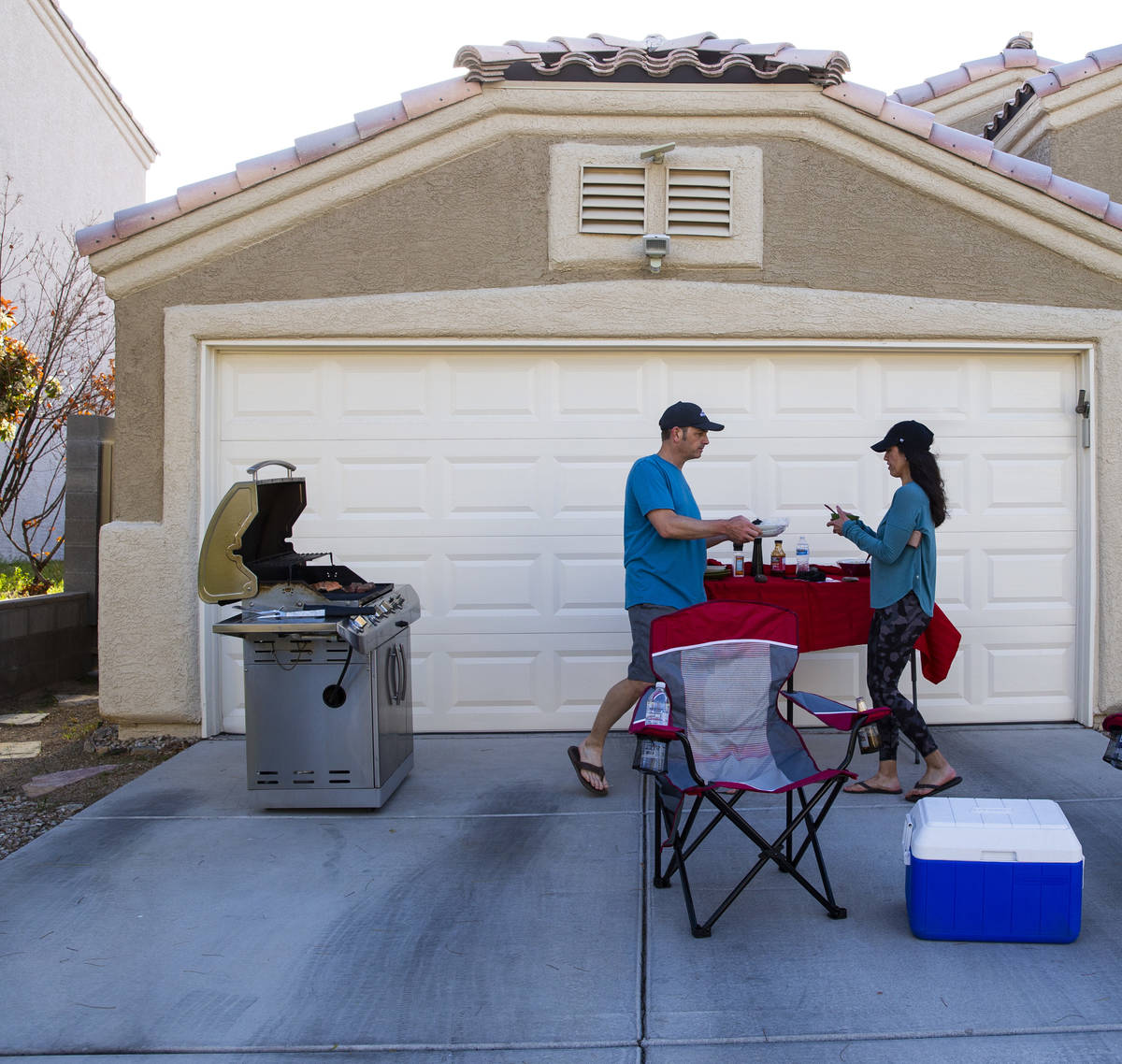 Kenny Atcheson and Jean Atcheson grill outside of their home while participating in a neighborh ...