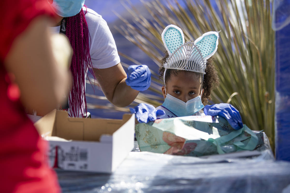 Christianna Clark, 6, finishes Easter baskets to be handed out to community members at Mountain ...