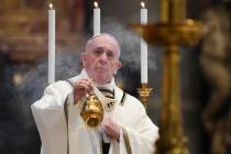 Pope Francis spreads incense at the start of Easter Sunday Mass, inside an empty St. Peter's Ba ...