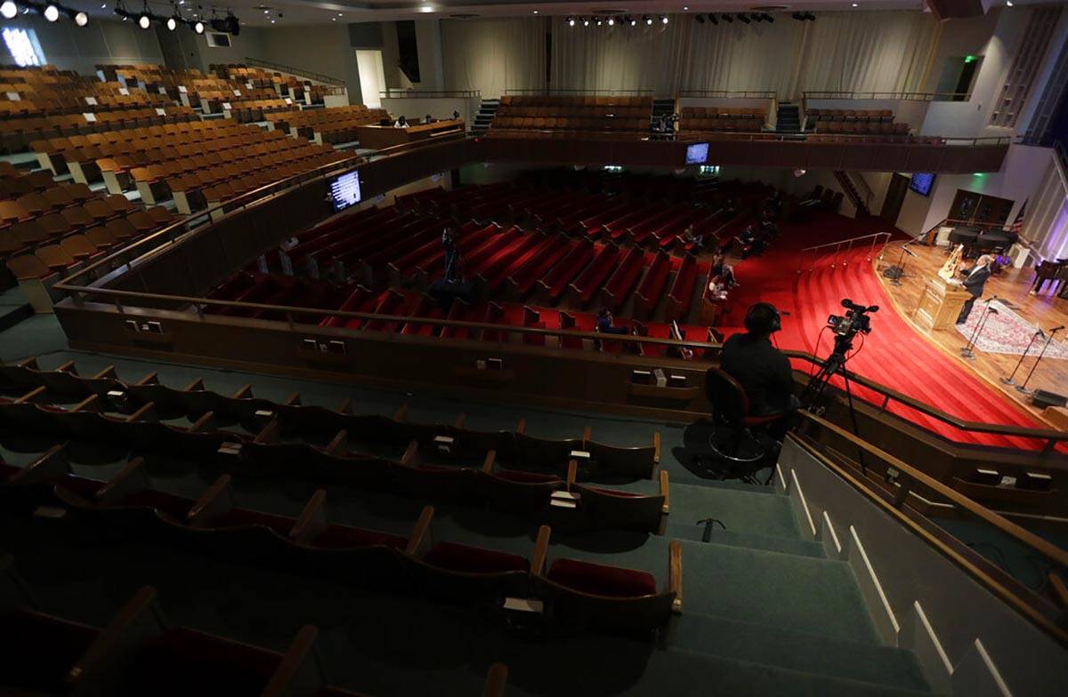 Pastor Les Hollon, right, holds an online Easter service at Trinity Baptist Church with a small ...