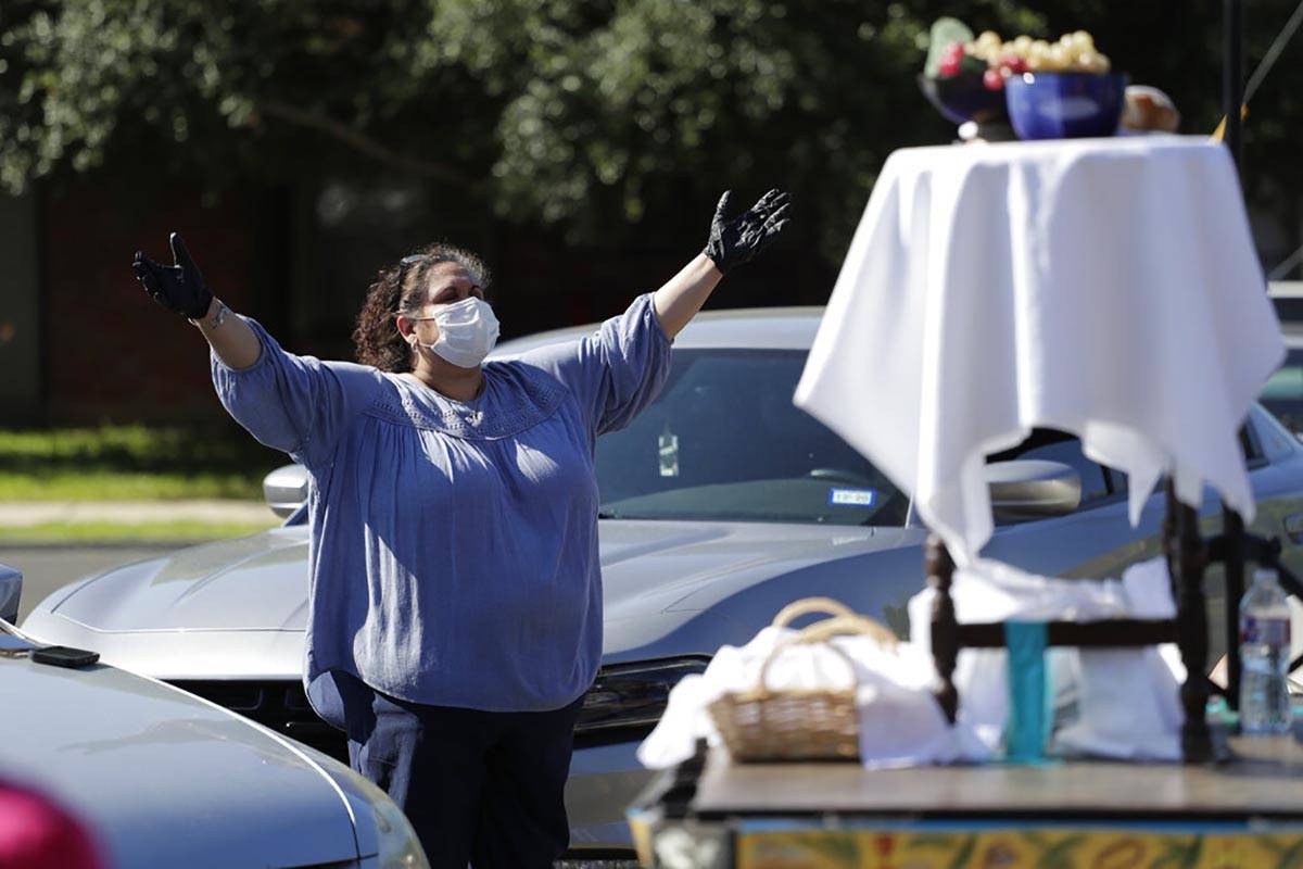 A church goer wears protective gloves and a face mask as she attends an Easter services in the ...