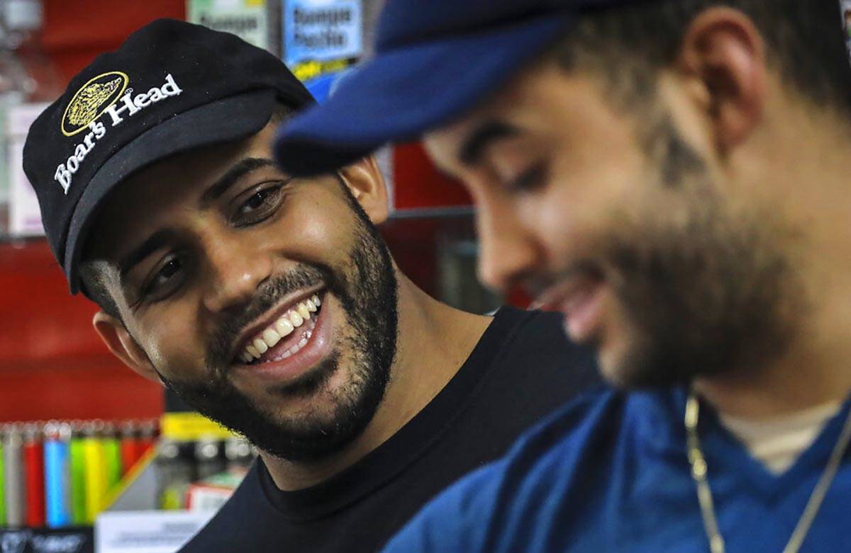 Alex Batista, left, talks with his brother Eudis Batista, owners of Deli-licious delicatessen i ...