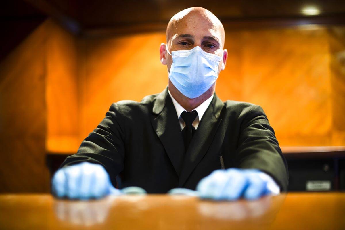 Concierge Joe DeLuca, poses for a photograph at the front desk of an apartment building in New ...