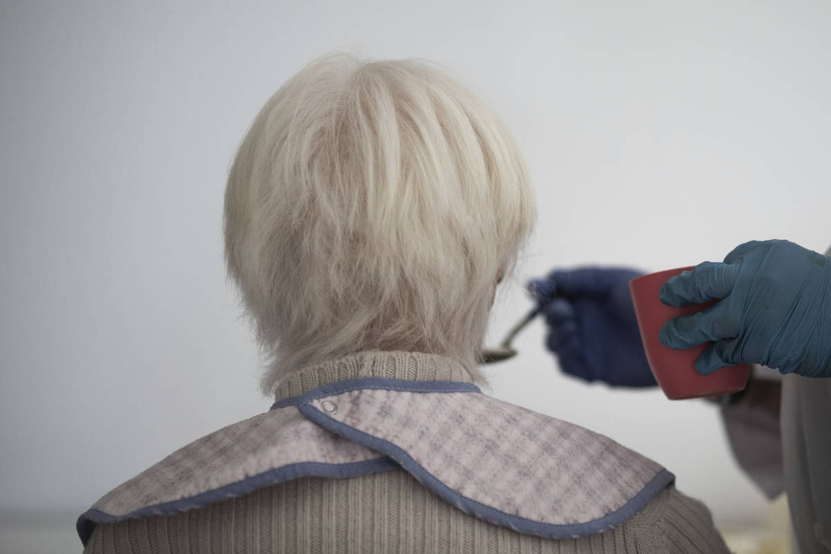 In this April 9, 2020 photo, a resident of "Las Praderas" elderly care home is feeded ...