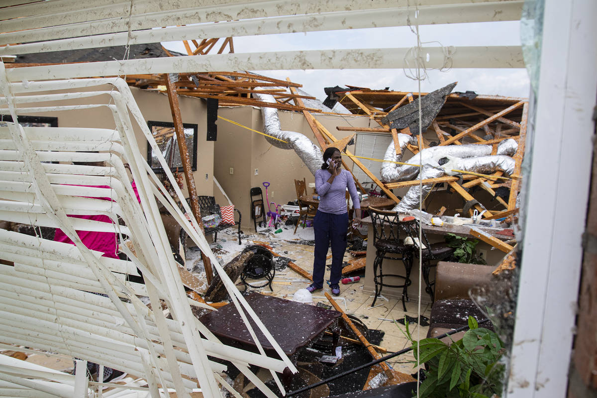 Rolanda Robinson calls family and friends from her brother's damaged home in Monroe, La. after ...