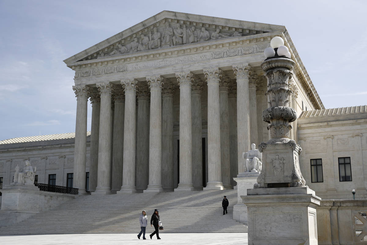 In this March 16, 2020 photo, people walk outside the Supreme Court in Washington. (AP Photo/P ...