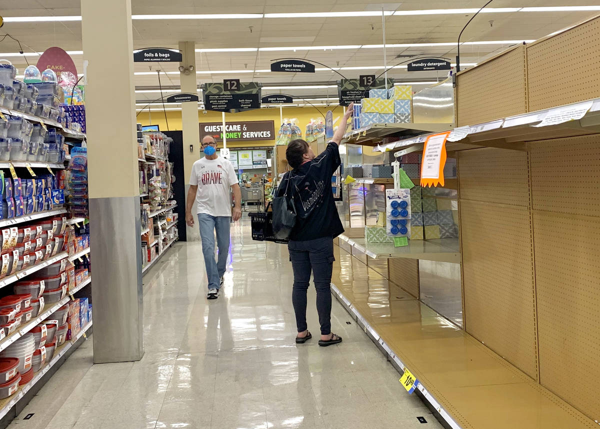 The bath tissue aisle is nearly empty as shoppers pass through at a Smith's store in Henderson ...