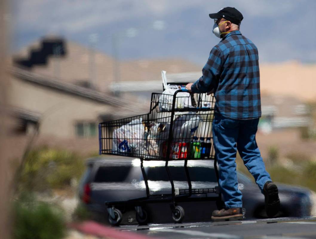 Shoppers wear protective masks outside Albertsons at North Hualapai Way in the northwest valley ...