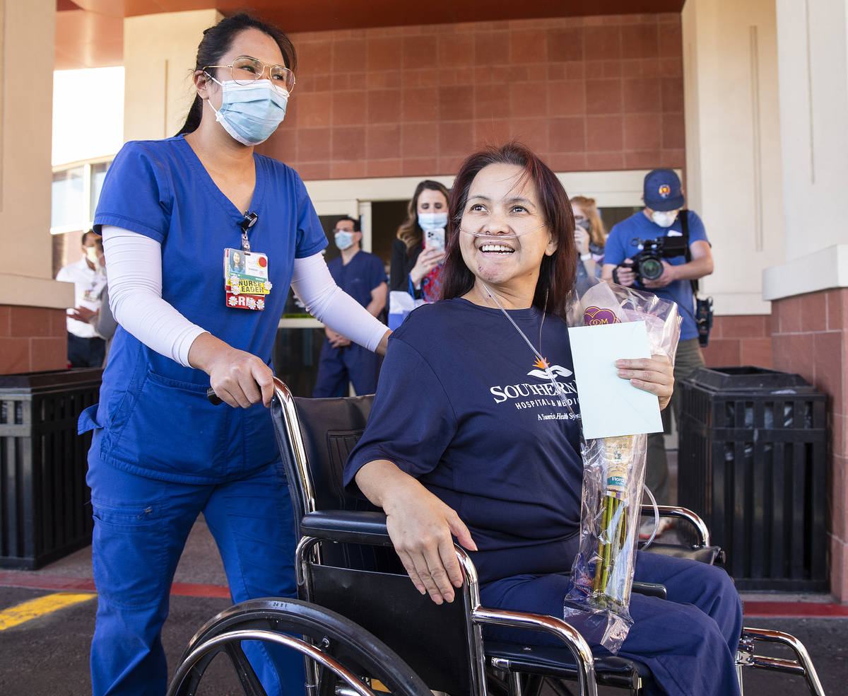 MountainView Hospital nurse Bessy Angue, bottom/right, is wheeled out of Southern Hills Hospita ...
