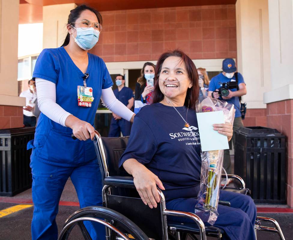 MountainView Hospital nurse Bessy Angue, bottom/right, is wheeled out of Southern Hills Hospita ...