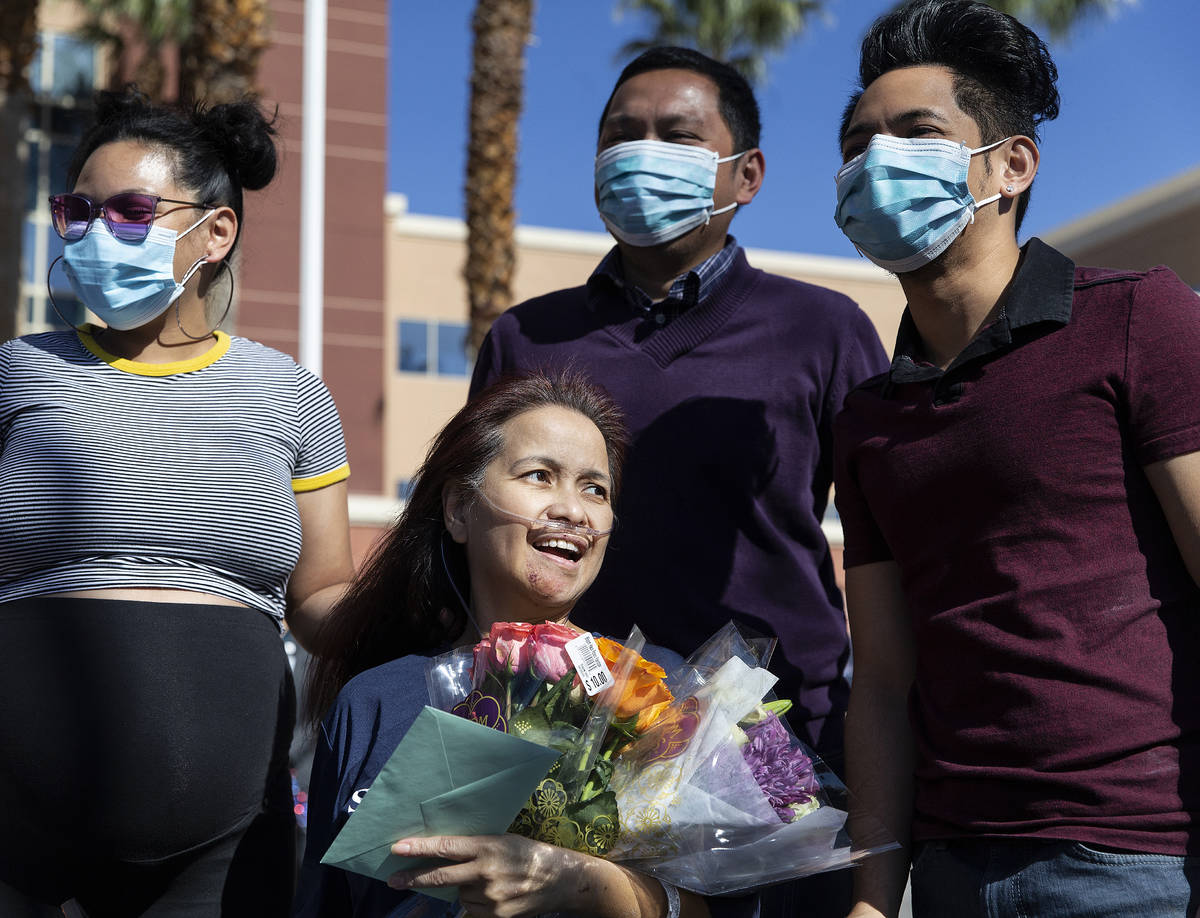 MountainView Hospital nurse Bessy Angue, middle, is greeted by friends, family and medical staf ...
