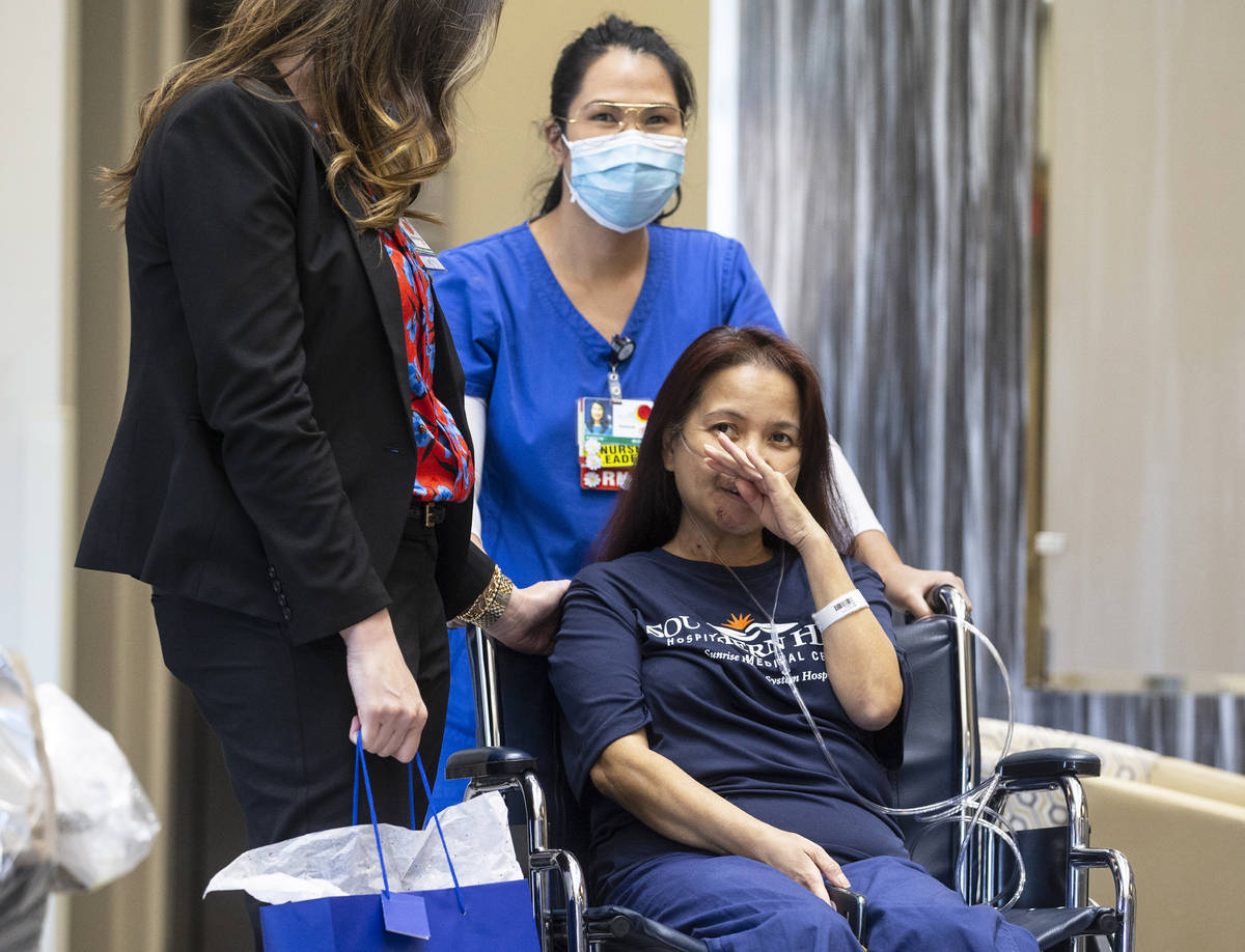 MountainView Hospital nurse Bessy Angue, bottom/right, wipes tears from her eyes as she's greet ...