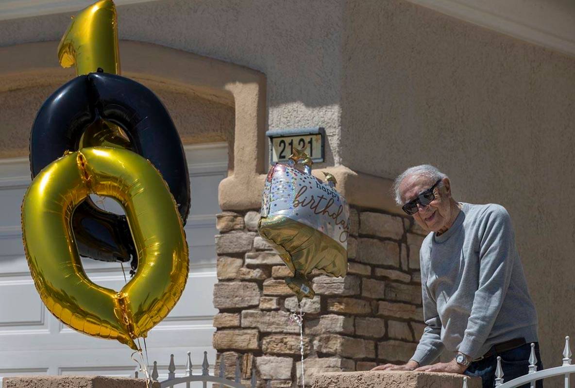 Henry Kronberg looks to friends stopping by his home to help him celebrate his 100th birthday d ...