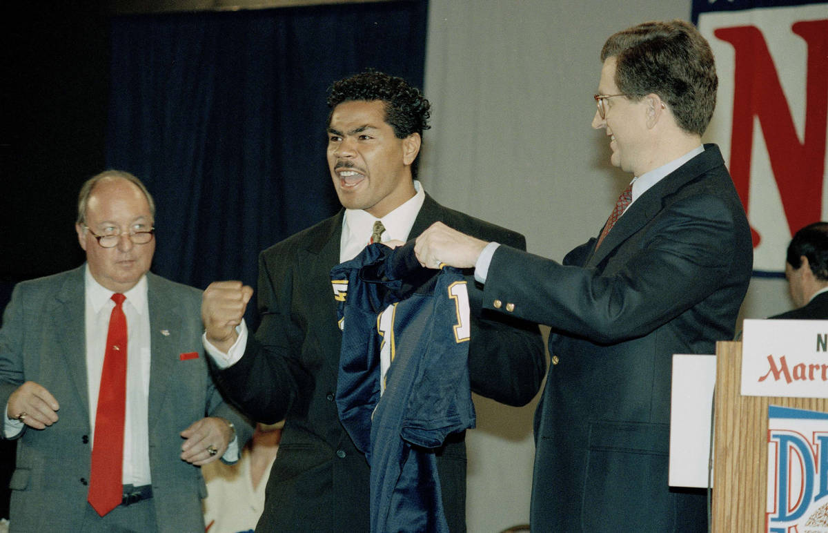 Junior Seau of Southern California makes a fist in jubilation while holding jersey with NFL Com ...
